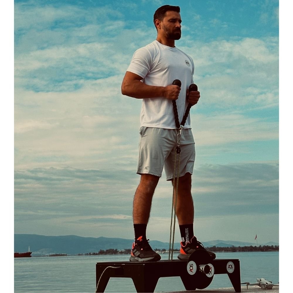 AOS Eco Pro Flywheel (Isoinertial) Antrenman ve Rehabilitasyon Sistemi 5 AOS Eco Pro üzerinde ayakta çekiş egzersizi yapan sporcu